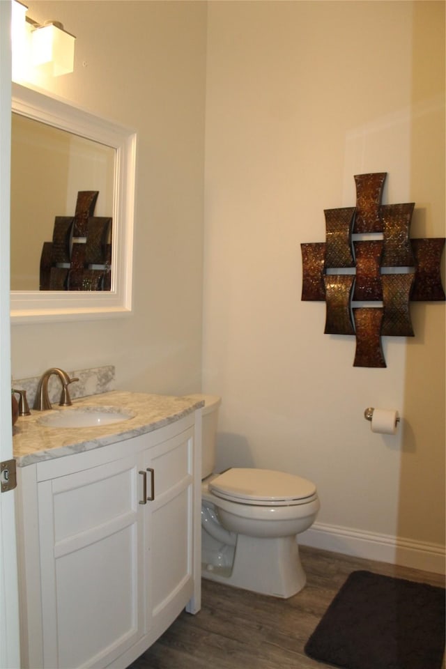 bathroom featuring vanity, wood-type flooring, and toilet