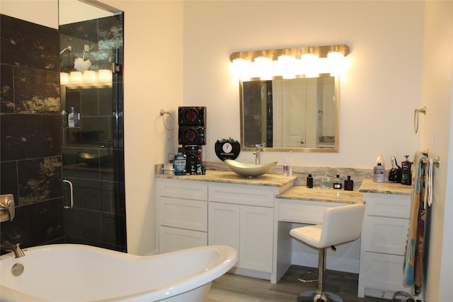 bathroom with vanity, hardwood / wood-style floors, and a bathtub