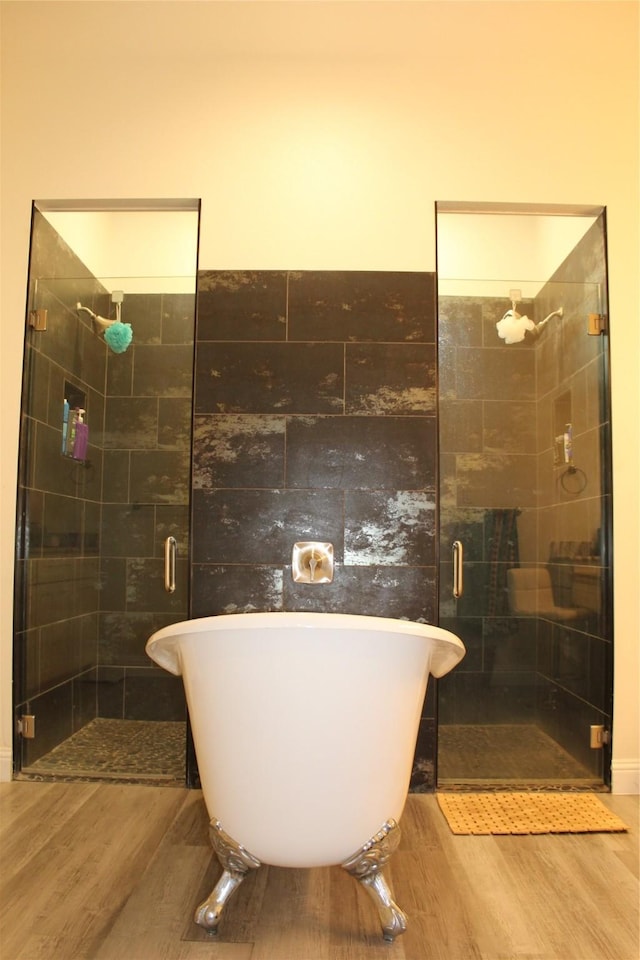 bathroom featuring wood-type flooring and separate shower and tub