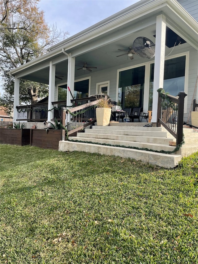 rear view of property with ceiling fan, a porch, and a yard