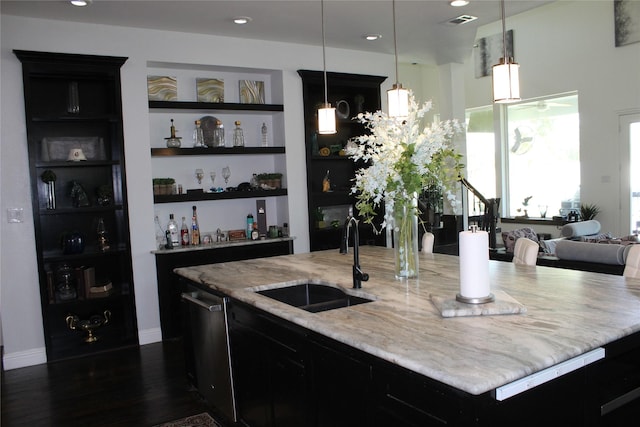 bar with pendant lighting, sink, light stone counters, and dishwasher