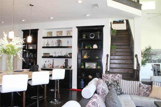 bar with built in features, dark hardwood / wood-style flooring, and decorative light fixtures