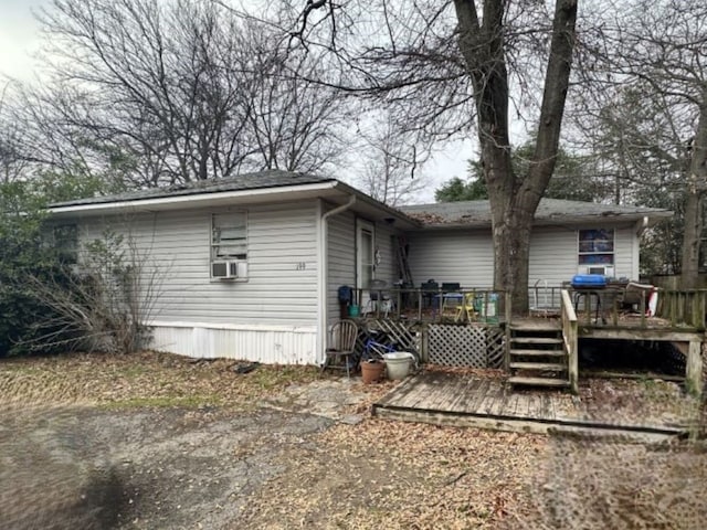 rear view of house with a wooden deck and cooling unit