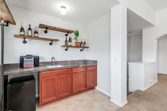 bar with light tile floors, sink, and fridge