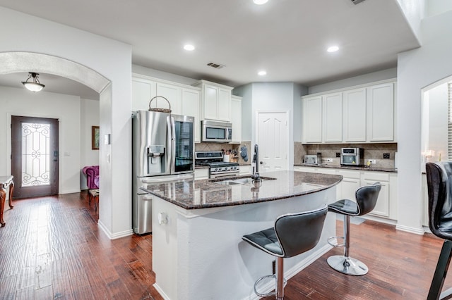 kitchen with white cabinets, sink, tasteful backsplash, and stainless steel appliances