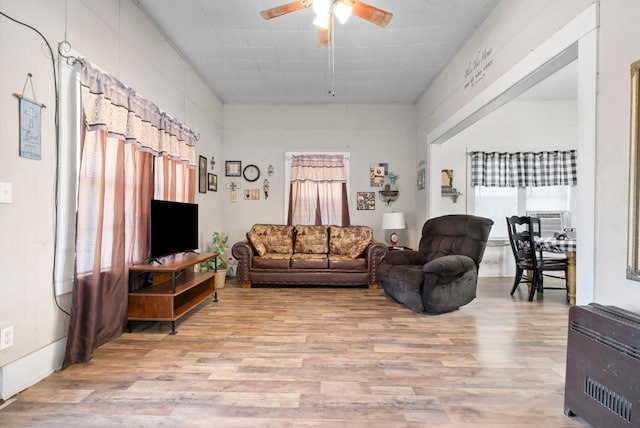 living room with plenty of natural light, ceiling fan, and light wood-type flooring