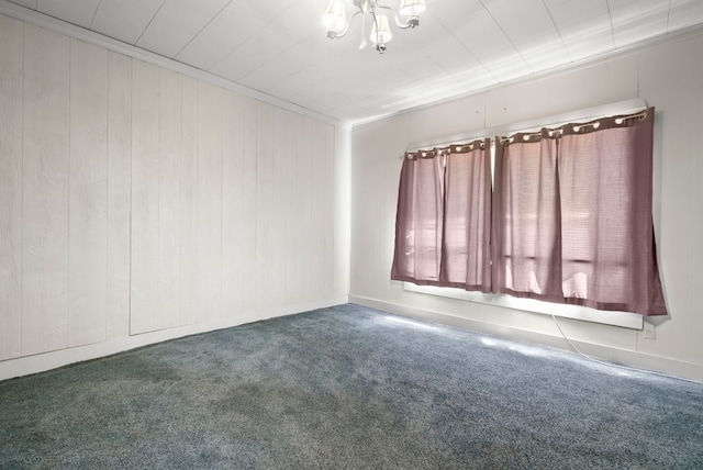 carpeted spare room featuring crown molding and a chandelier