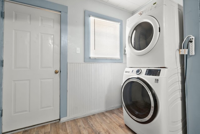 clothes washing area featuring stacked washer / dryer and light hardwood / wood-style floors