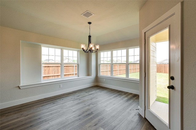 unfurnished room featuring a notable chandelier and wood-type flooring