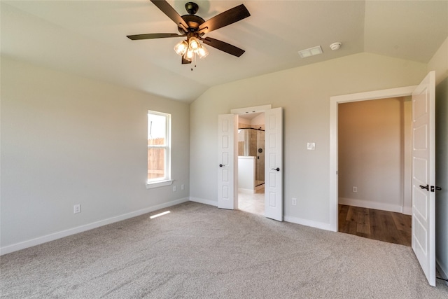 unfurnished bedroom featuring lofted ceiling and light carpet