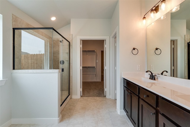 bathroom featuring a shower with door, tile floors, and vanity