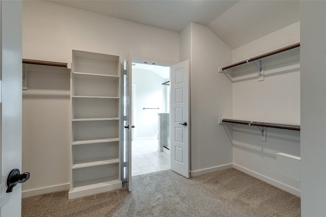 walk in closet featuring light carpet and lofted ceiling