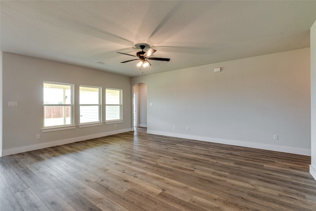 empty room with dark hardwood / wood-style flooring and ceiling fan