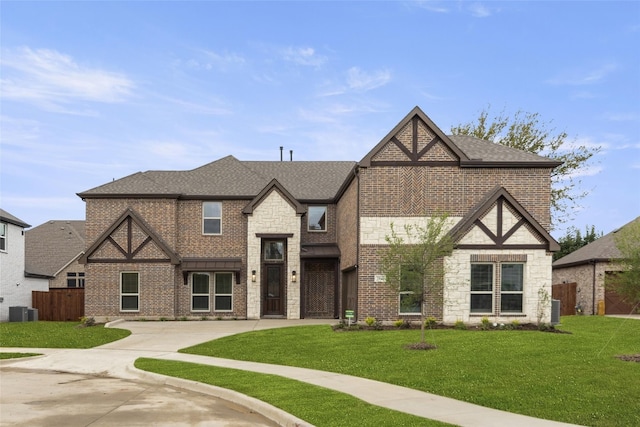 tudor-style house with central air condition unit and a front yard