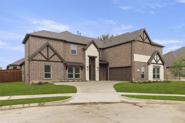 tudor-style house featuring a front yard and a garage