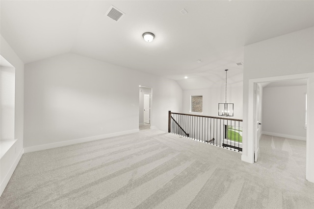 interior space with an inviting chandelier, lofted ceiling, and light carpet