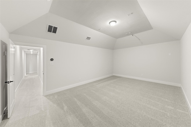 empty room featuring light carpet and vaulted ceiling