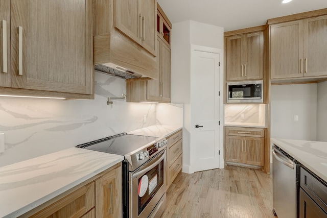 kitchen featuring light hardwood / wood-style floors, light stone countertops, light brown cabinetry, and stainless steel appliances