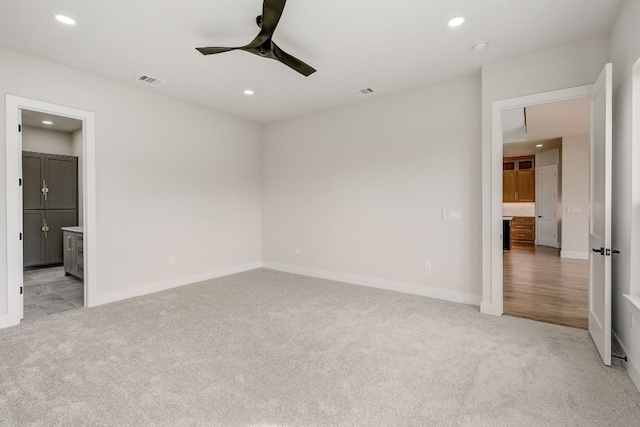 carpeted spare room featuring ceiling fan