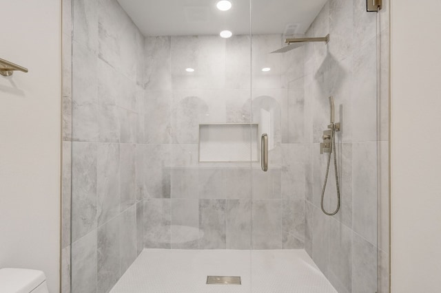 bathroom featuring walk in shower and toilet