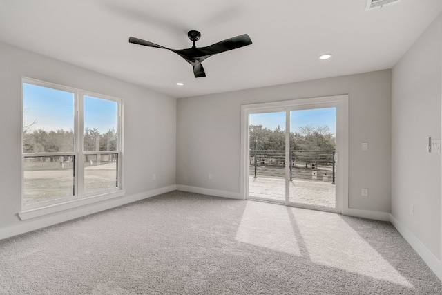 carpeted empty room featuring ceiling fan and plenty of natural light