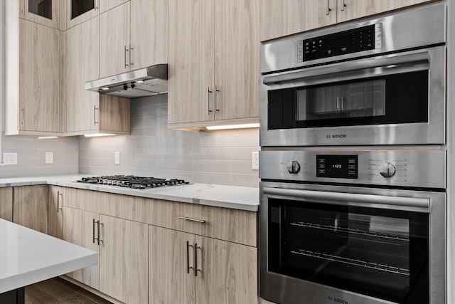 kitchen with decorative backsplash, appliances with stainless steel finishes, and light brown cabinets