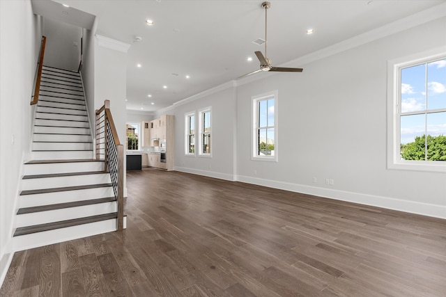 unfurnished living room with a wealth of natural light, dark wood-type flooring, and ceiling fan