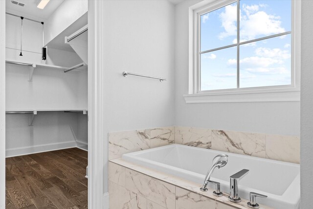 kitchen featuring light stone countertops, stainless steel dishwasher, sink, a center island, and dark hardwood / wood-style floors