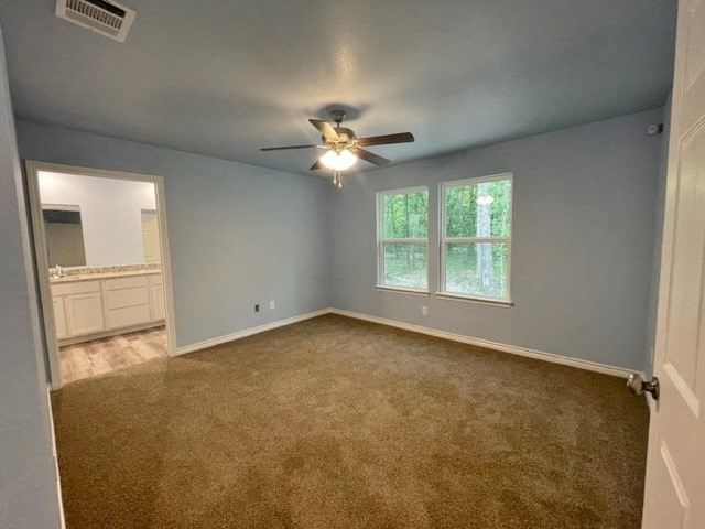 carpeted spare room featuring ceiling fan