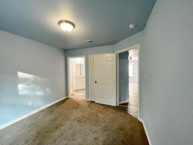 unfurnished bedroom with dark colored carpet