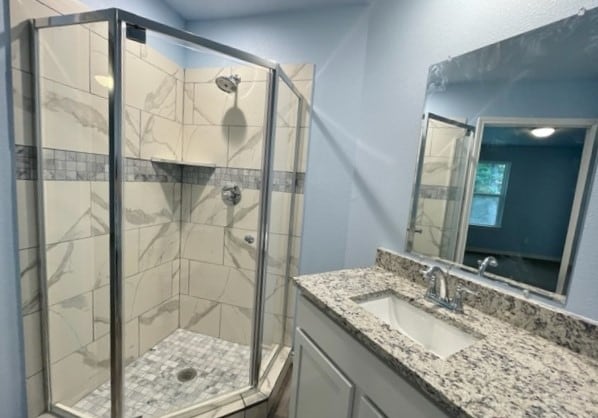 bathroom with an enclosed shower and vanity