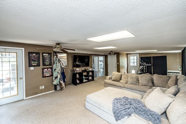 living room featuring ceiling fan and a textured ceiling