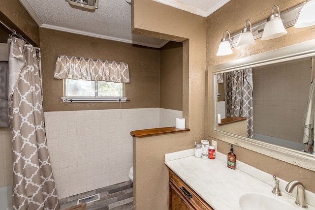 full bathroom featuring vanity, shower / bath combination with curtain, crown molding, toilet, and a textured ceiling