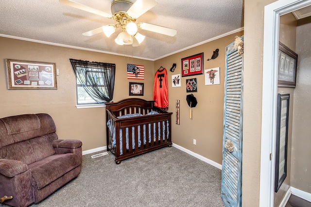 bedroom with crown molding, carpet flooring, ceiling fan, a textured ceiling, and a nursery area