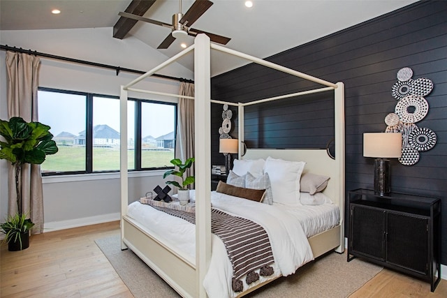 bedroom featuring ceiling fan, lofted ceiling with beams, and light wood-type flooring