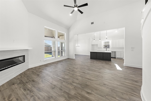 unfurnished living room featuring sink, high vaulted ceiling, ceiling fan, and hardwood / wood-style flooring