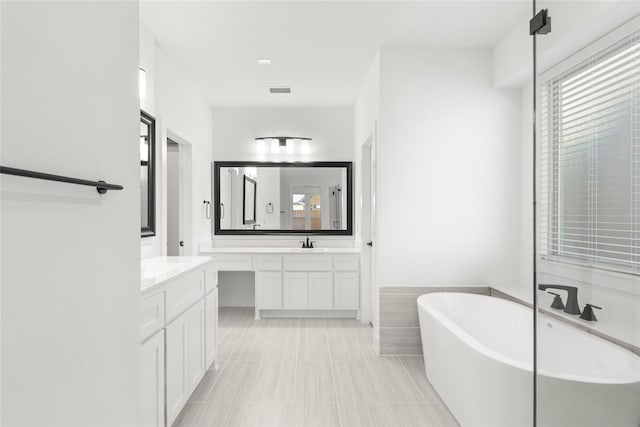 bathroom featuring a washtub, tile patterned floors, and vanity