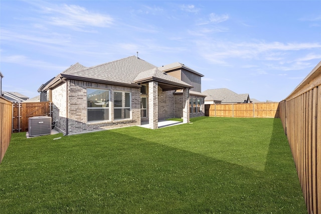 back of house featuring central AC, a patio area, and a yard