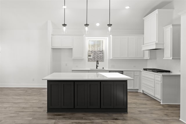 kitchen with white cabinetry, light hardwood / wood-style floors, and a kitchen island