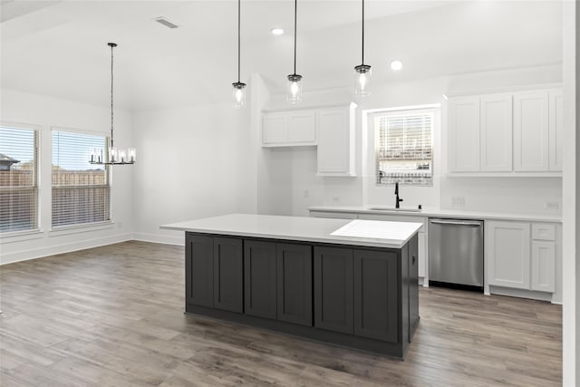 kitchen featuring plenty of natural light, a kitchen island, dishwasher, and light wood-type flooring