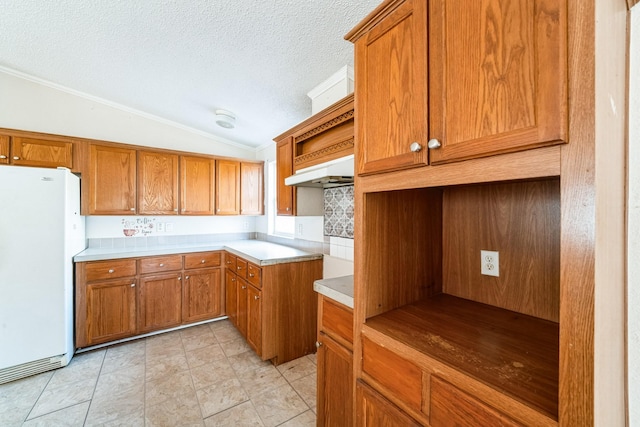 kitchen with backsplash, white refrigerator, ornamental molding, a textured ceiling, and vaulted ceiling