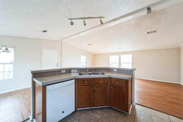 kitchen with lofted ceiling, sink, a center island with sink, and white dishwasher