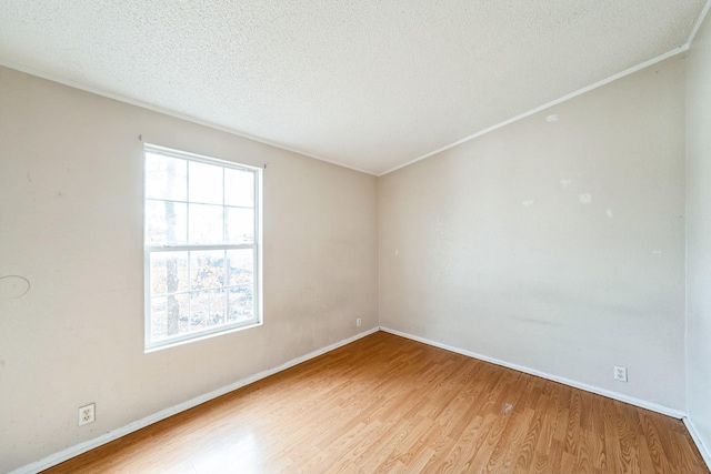 unfurnished room with ornamental molding, a textured ceiling, and light hardwood / wood-style floors