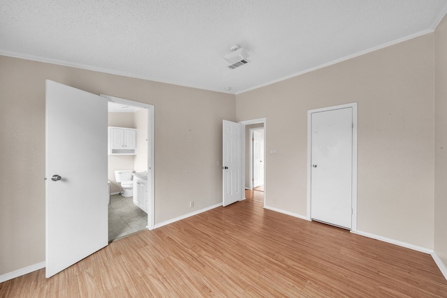 unfurnished bedroom with ornamental molding, a textured ceiling, ensuite bath, and light hardwood / wood-style flooring