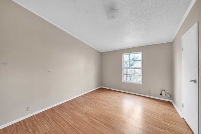 empty room featuring crown molding, light hardwood / wood-style flooring, and a textured ceiling