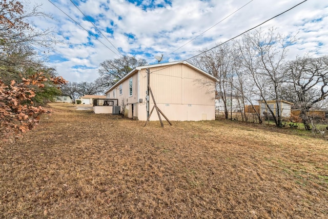 view of home's exterior with a yard and central AC unit