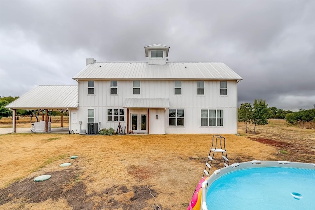 rear view of house featuring french doors, central AC unit, and a carport