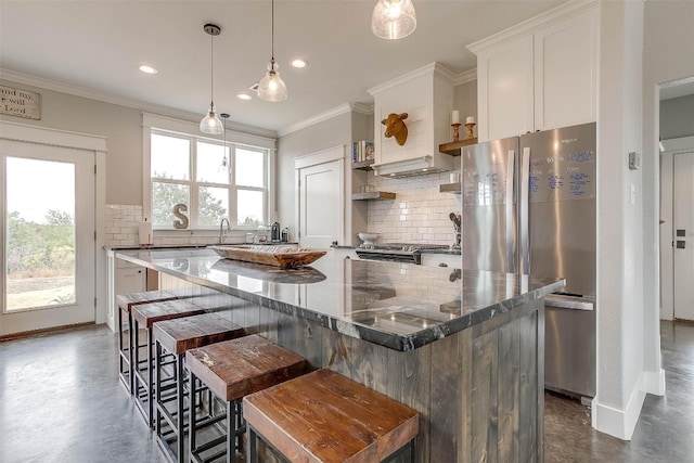 kitchen with white cabinetry, plenty of natural light, a kitchen island, and appliances with stainless steel finishes