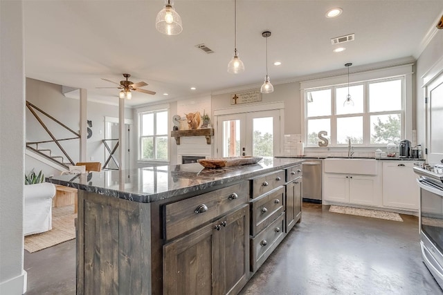 kitchen featuring stainless steel appliances, white cabinets, pendant lighting, and a kitchen island