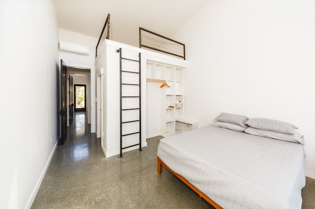 bedroom with concrete flooring, a wall unit AC, a closet, and a high ceiling